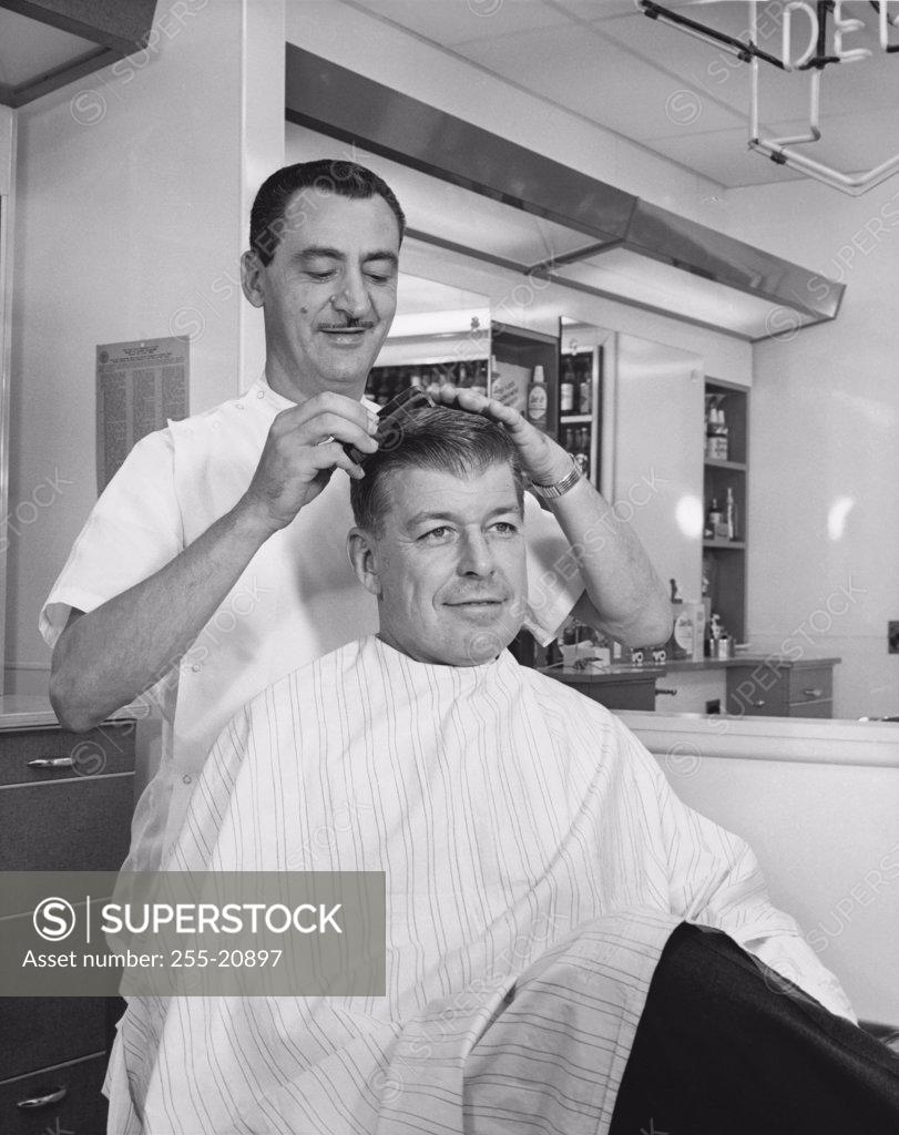 Stock Photo: 255-20897 Mid adult man getting a hair cut from a barber