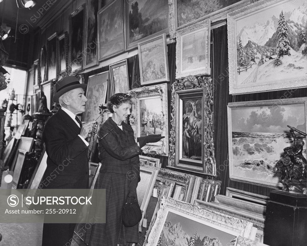 Stock Photo: 255-20912 Side profile of a mature couple looking at paintings in a store