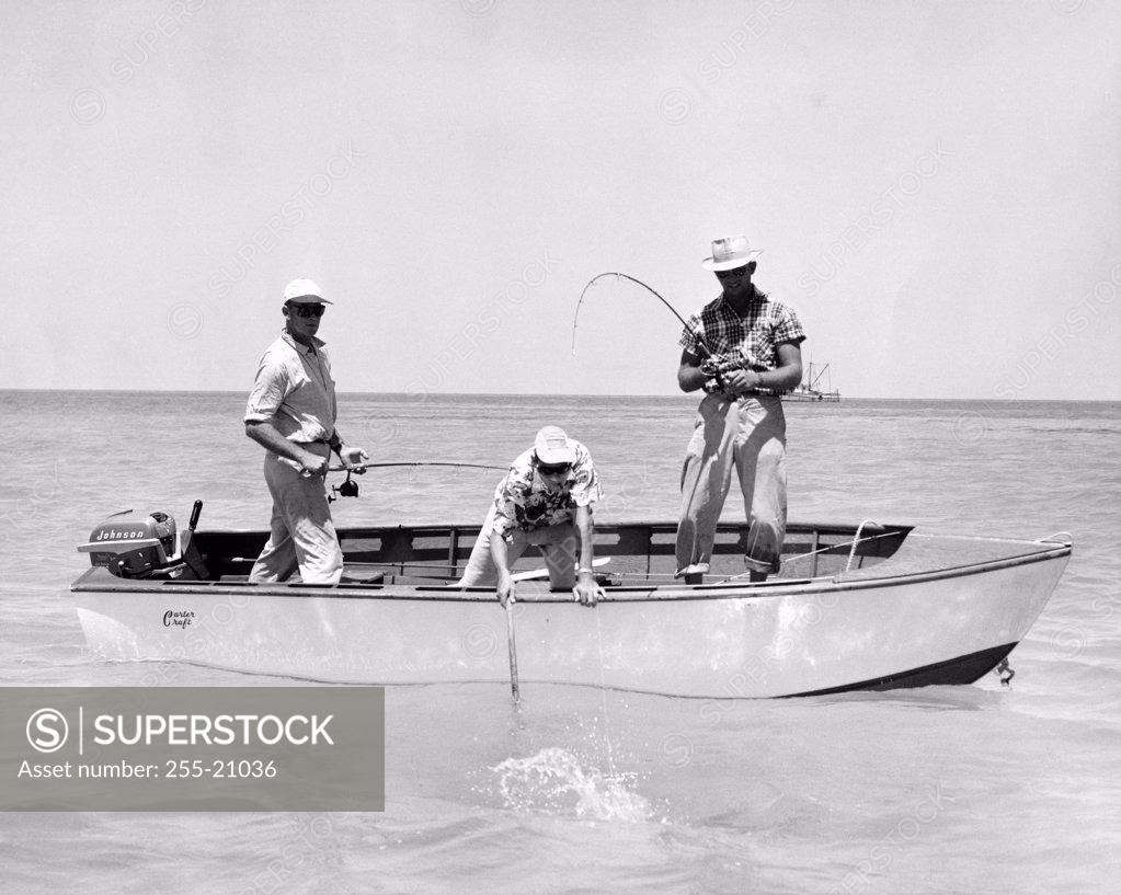 Stock Photo: 255-21036 Three men fishing in sea