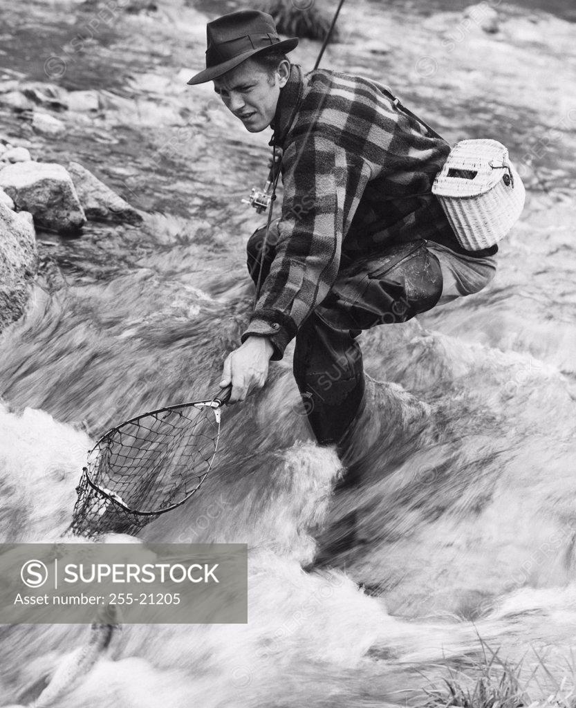 Stock Photo: 255-21205 Side profile of a mid adult man fishing in a river