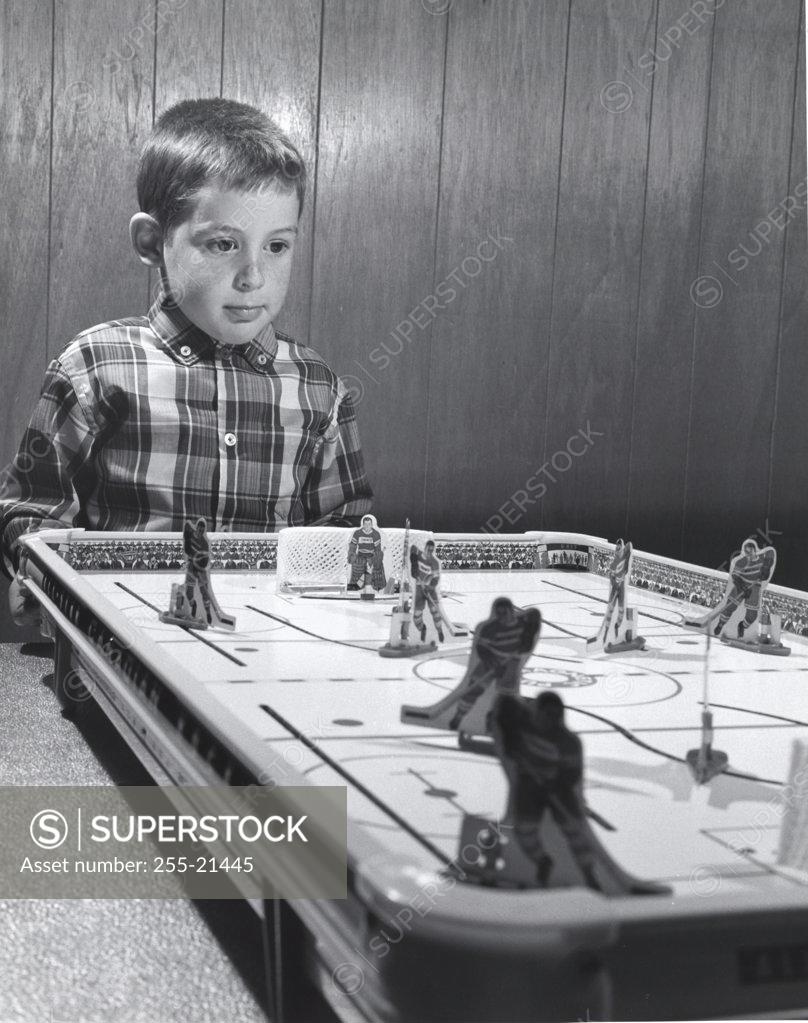 Stock Photo: 255-21445 Boy standing near an ice hockey table