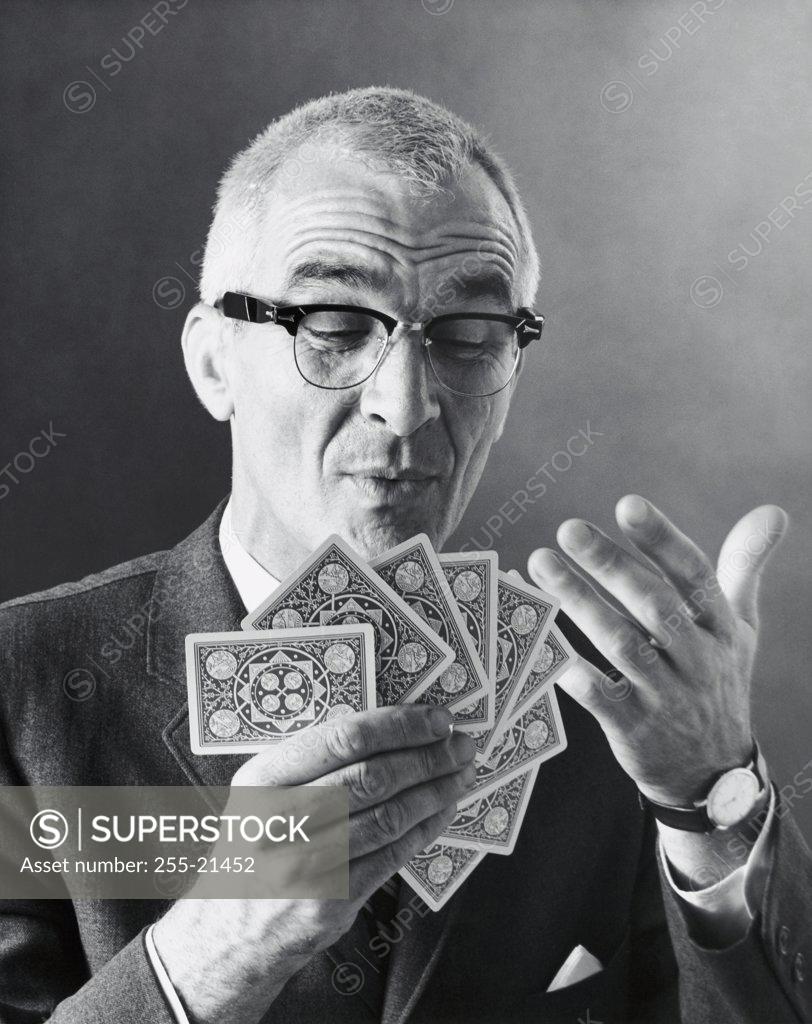 Stock Photo: 255-21452 Close-up of a mature man holding playing cards