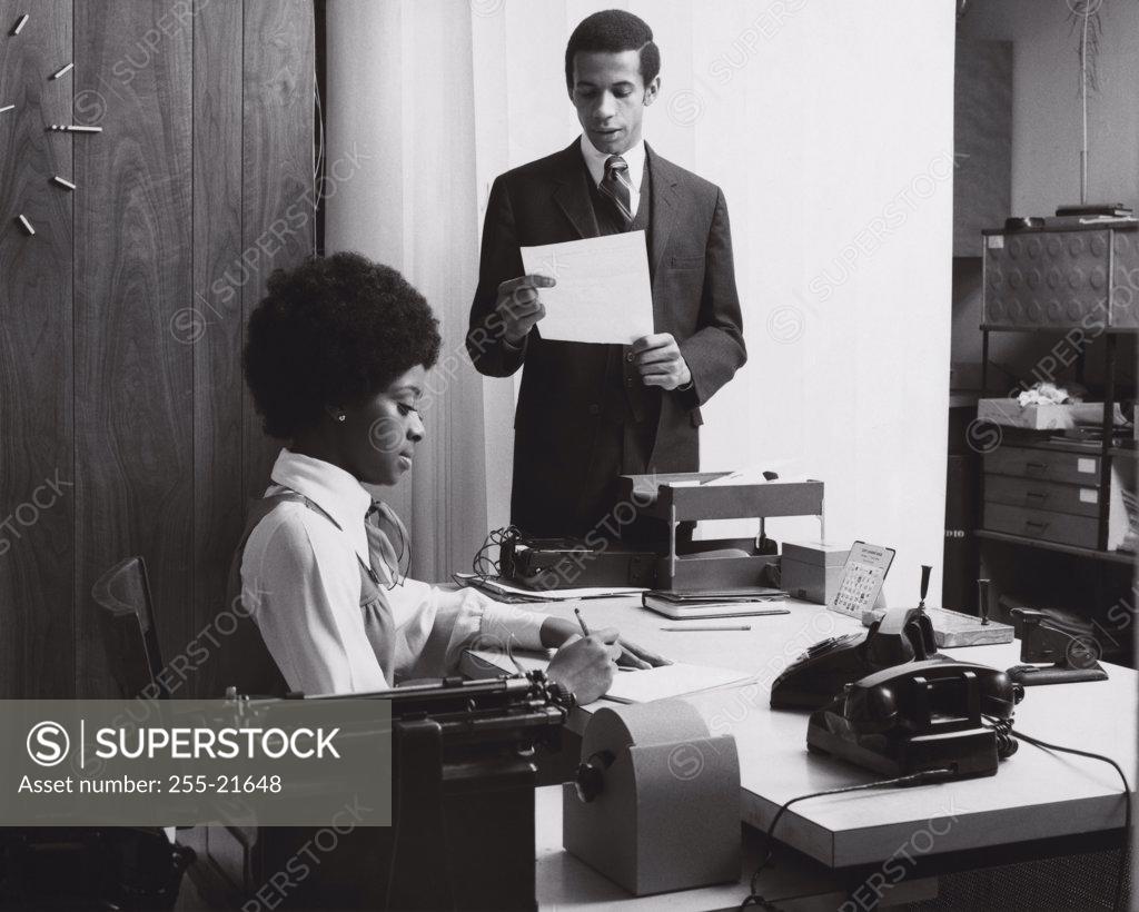 Stock Photo: 255-21648 Businessmen dictating a letter to his secretary
