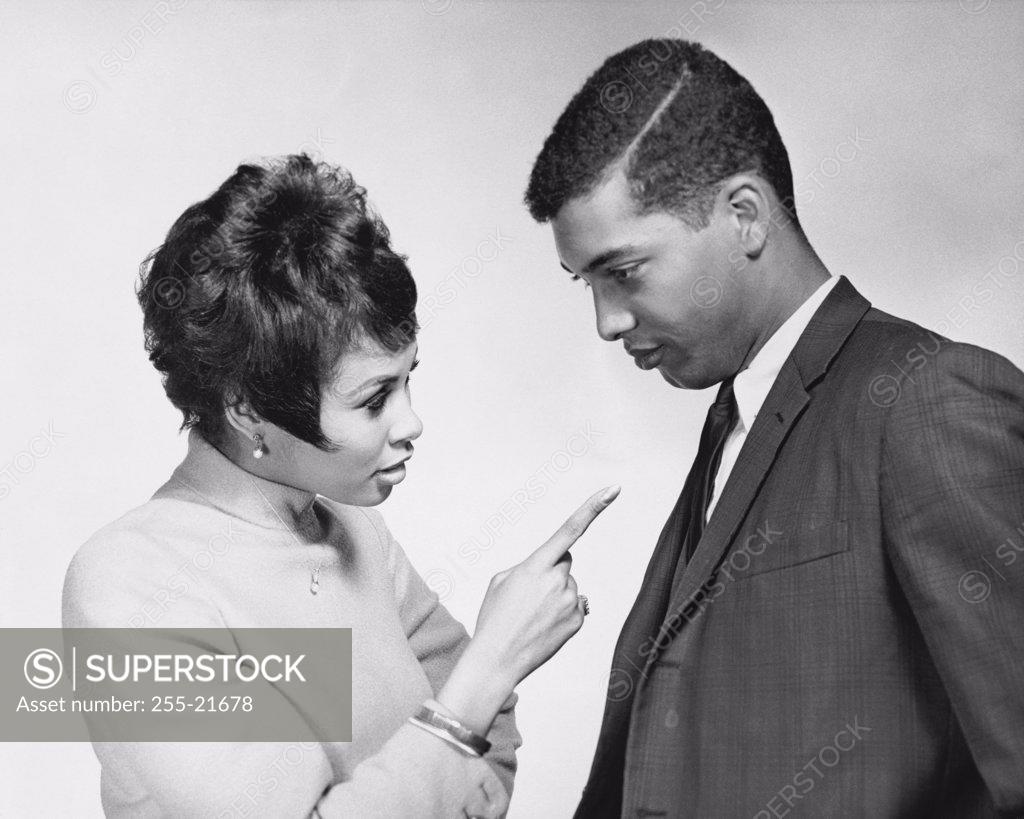 Stock Photo: 255-21678 Side profile of a young woman pointing her finger at a young man