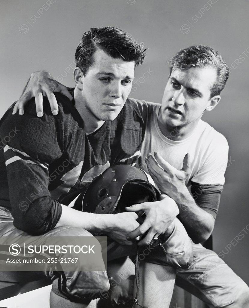 Stock Photo: 255-21767 Young man consoling a football player