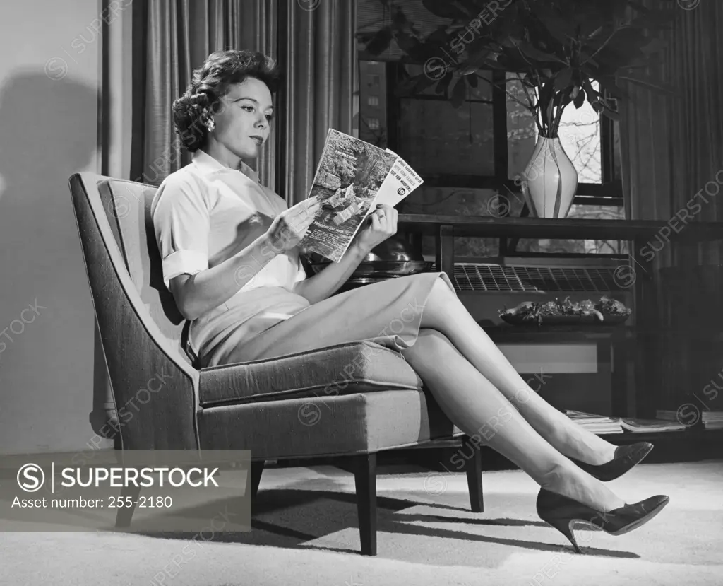 Side profile of a young woman reading a magazine