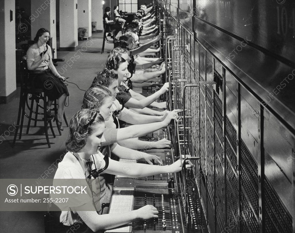 Stock Photo: 255-2207 Group of female telephone operators operating telephone switchboards