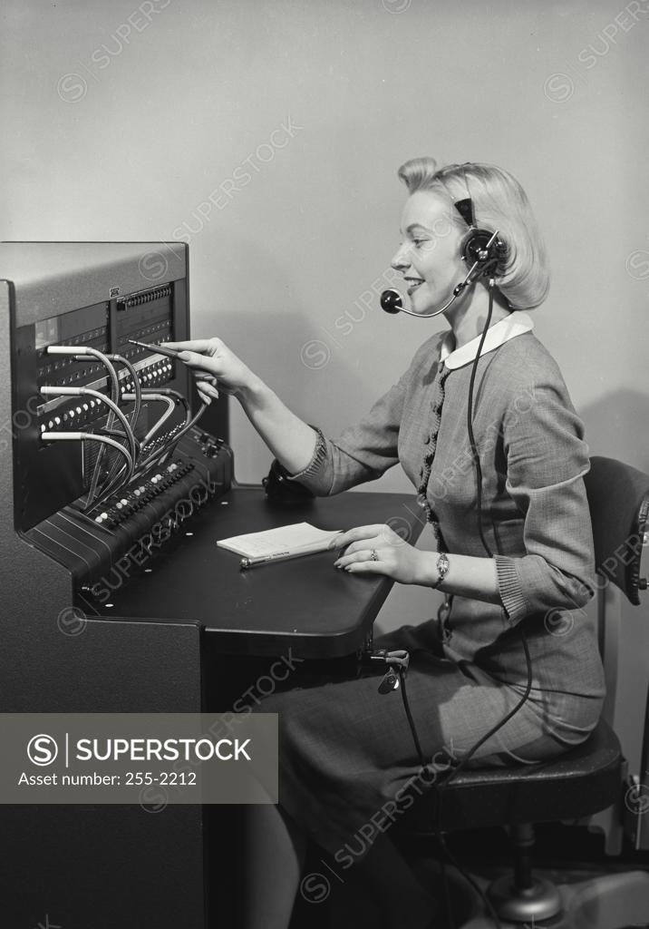 Stock Photo: 255-2212 Side profile of female telephone operator operating telephone switchboard