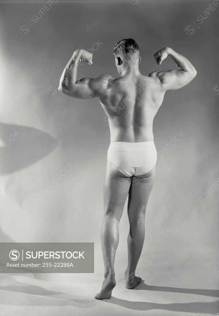 Stock Photo: 255-22288A Rear view of a man flexing his muscles