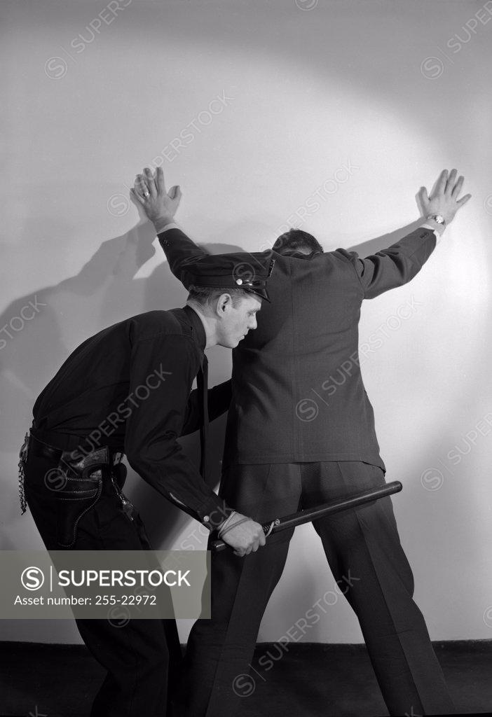 Stock Photo: 255-22972 Security guard checking man with metal detector