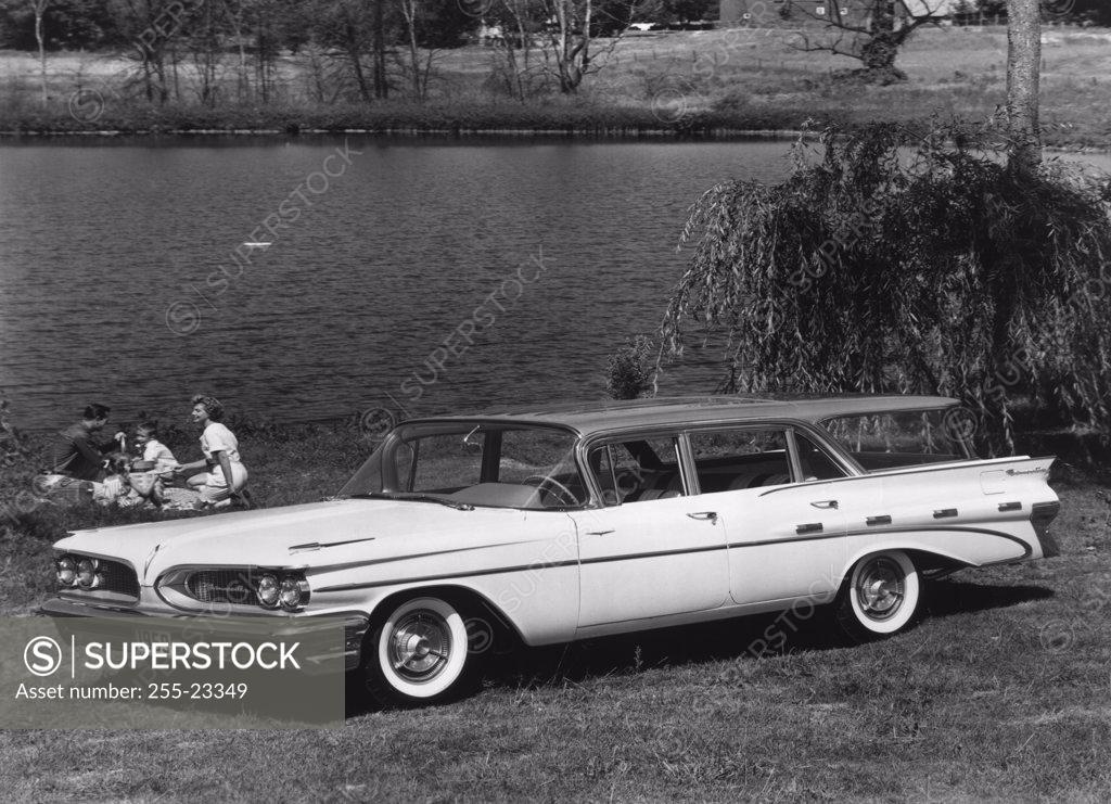 Stock Photo: 255-23349 Parents sitting with their child in a park near a lake, 1959 Bonneville Safari