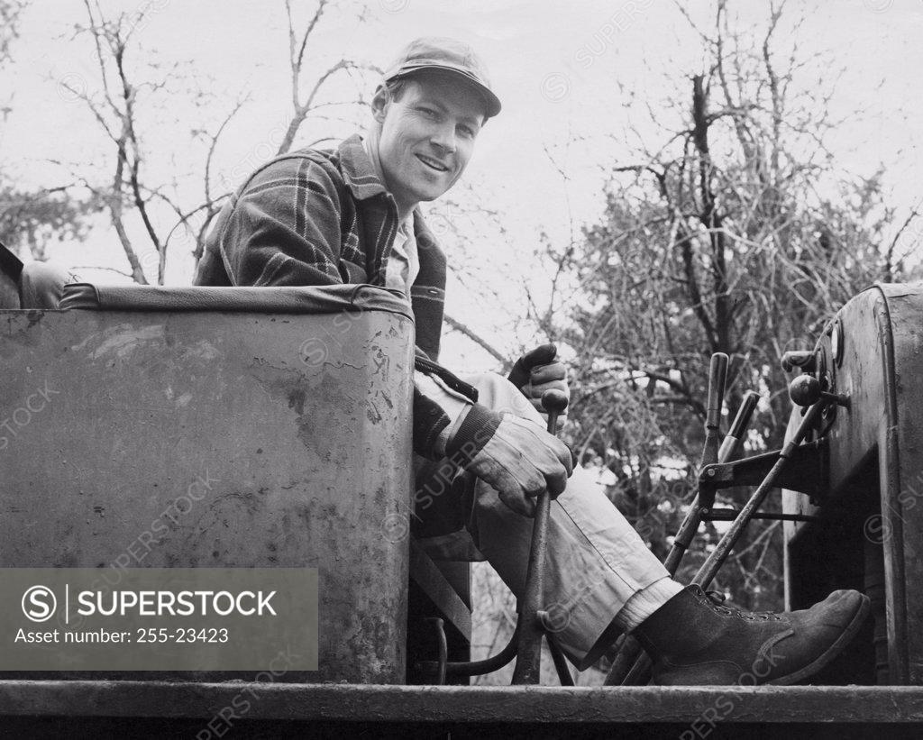 Stock Photo: 255-23423 Portrait of a worker sitting in a piece of construction equipment