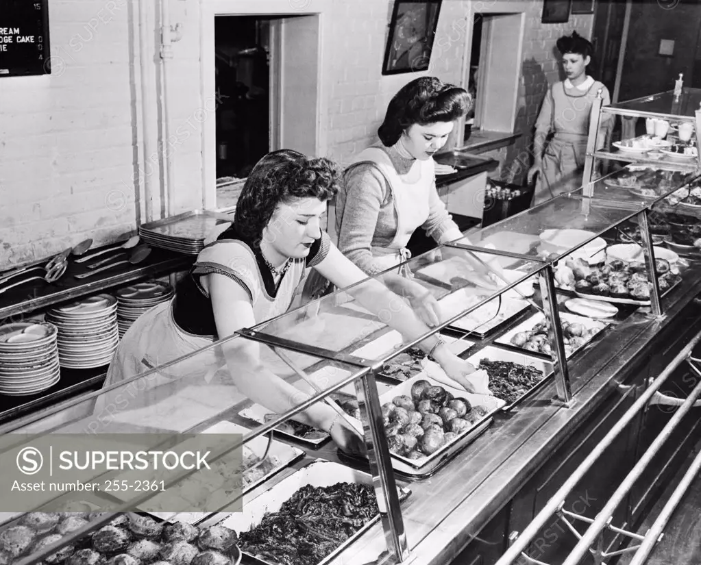 High angle view of three Home Economics Students serving food in a cafeteria, Hyattsville, Maryland, USA