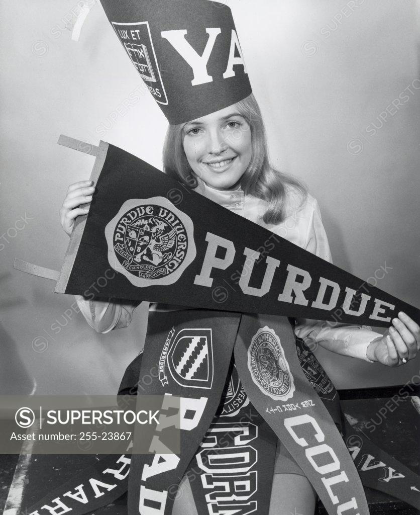 Stock Photo: 255-23867 Portrait of a young woman with college penants