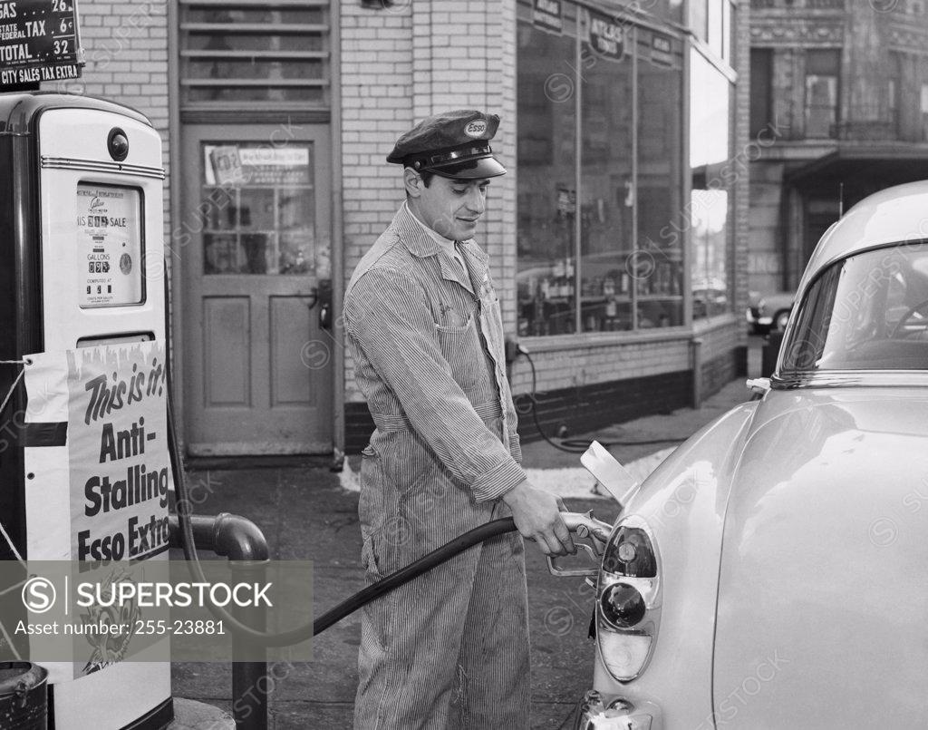 Stock Photo: 255-23881 Side profile of a gas station attendant filling up a car