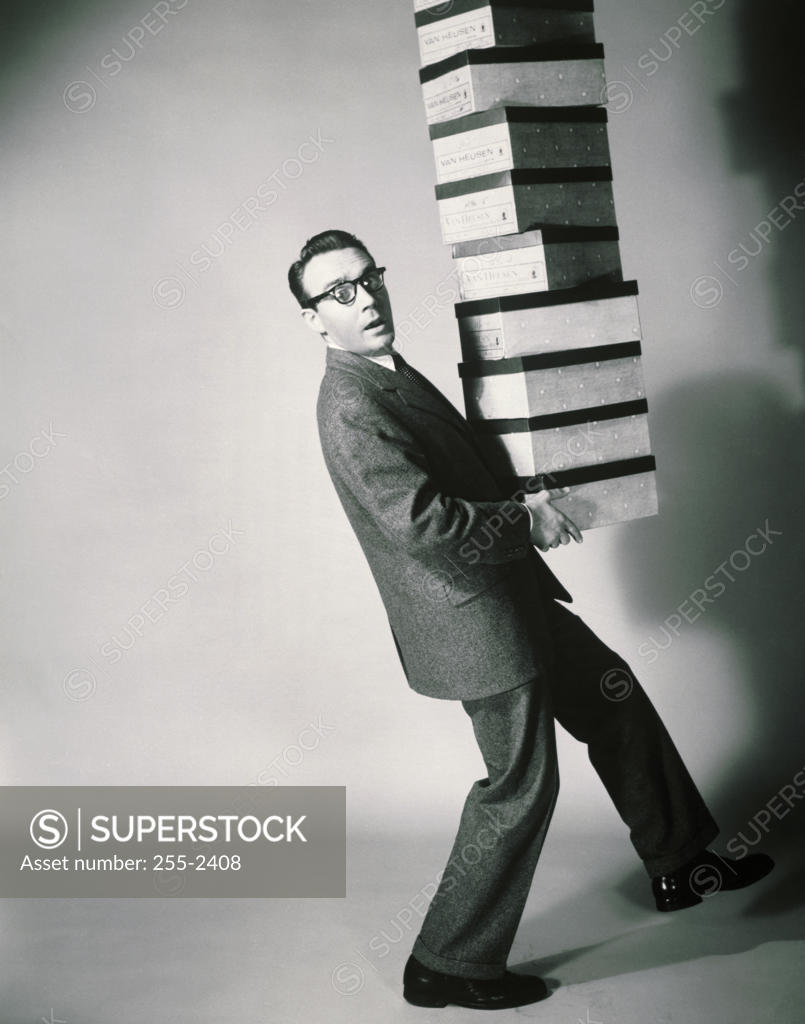 Stock Photo: 255-2408 Side profile of a salesman carrying a stack of shoeboxes