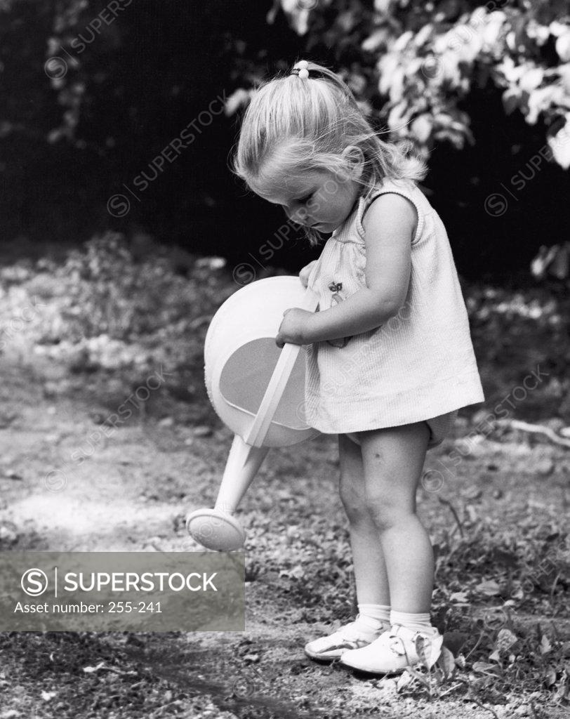 Stock Photo: 255-241 Side profile of a girl holding a watering can