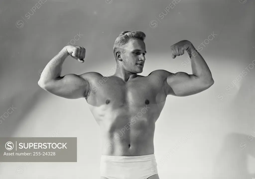 Close-up of a young man flexing his muscles