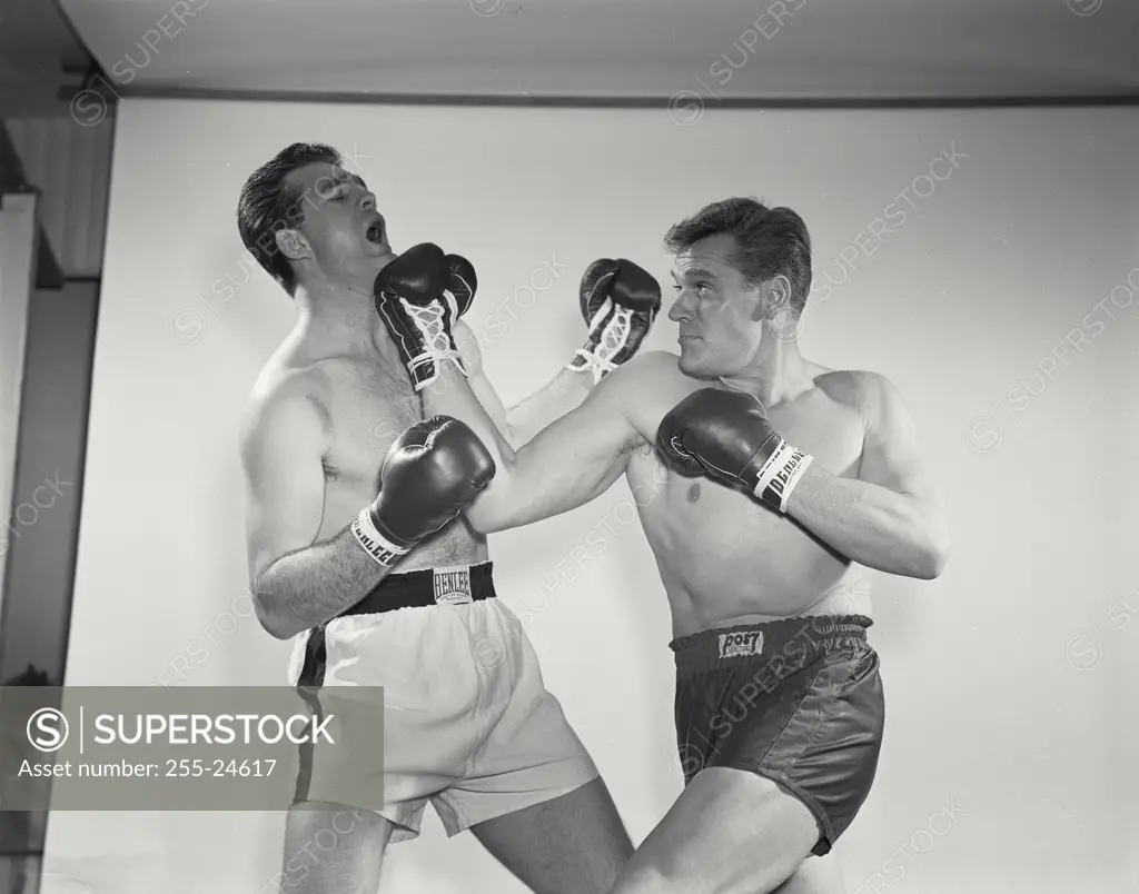 Two mid adult men boxing