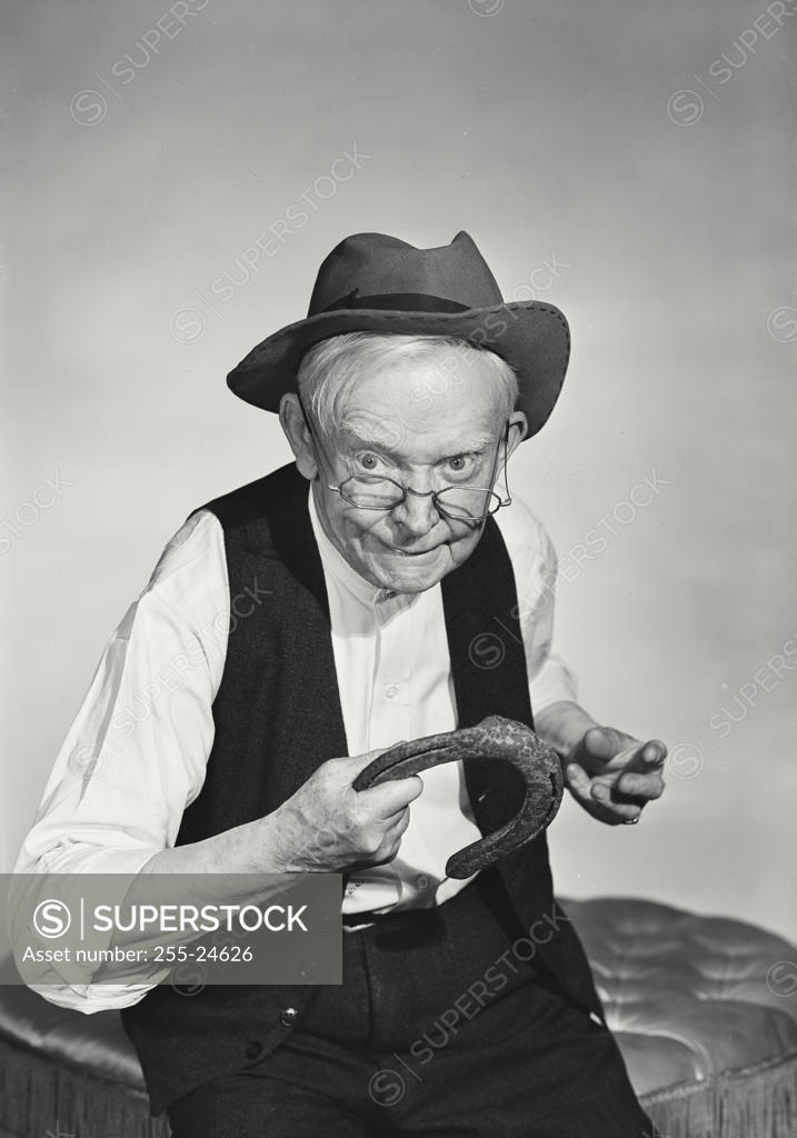 Stock Photo: 255-24626 Close-up of a senior man holding a horseshoe