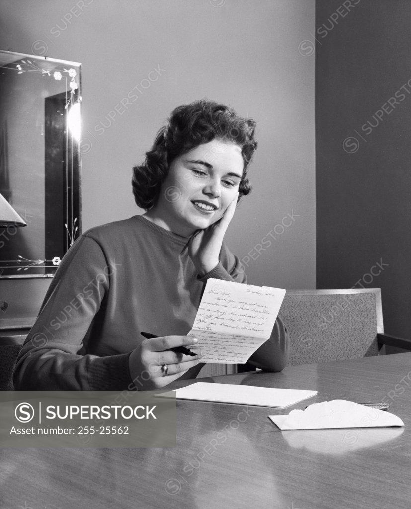 Stock Photo: 255-25562 Young woman reading a letter and smiling