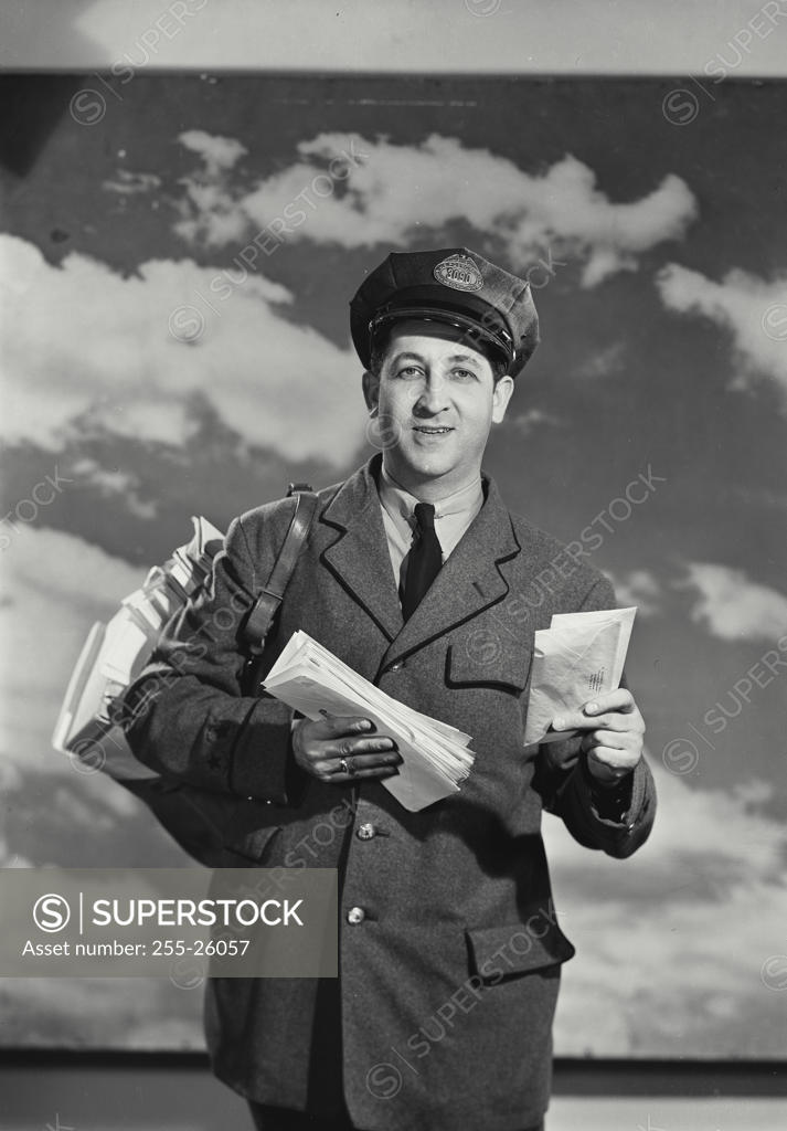 Stock Photo: 255-26057 Portrait of a mailman holding letters and smiling
