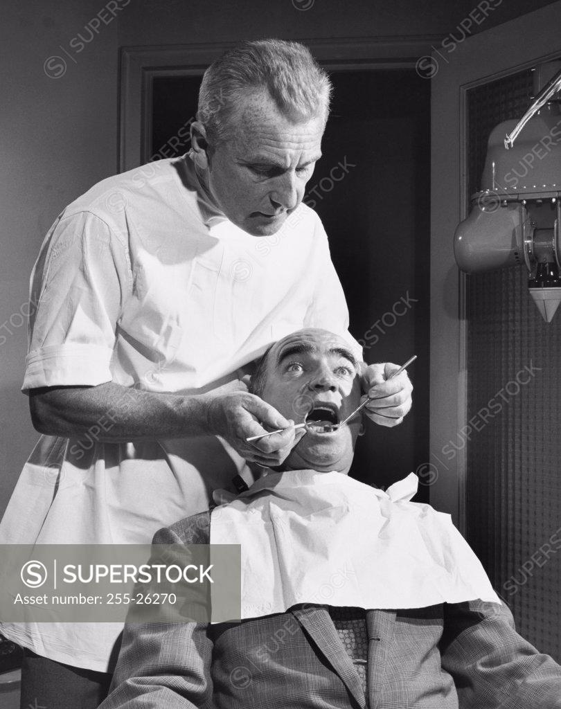Stock Photo: 255-26270 Terrified patient getting treatment from a dentist