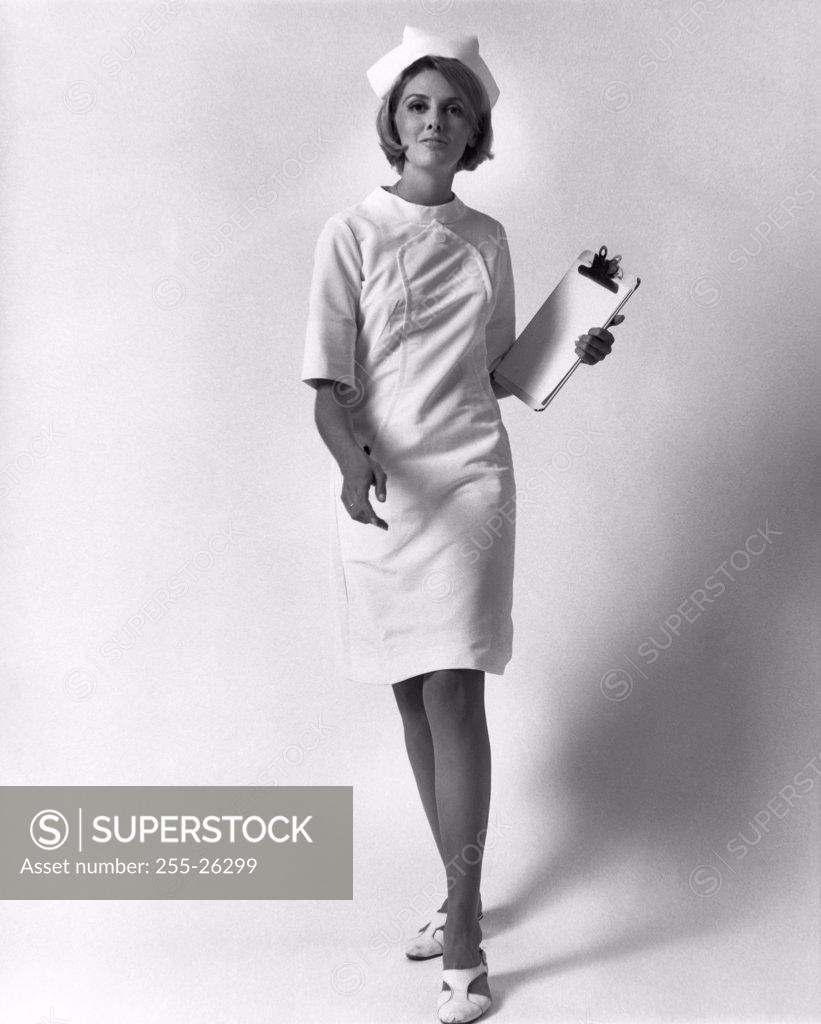 Stock Photo: 255-26299 Portrait of a female nurse walking and holding a clipboard