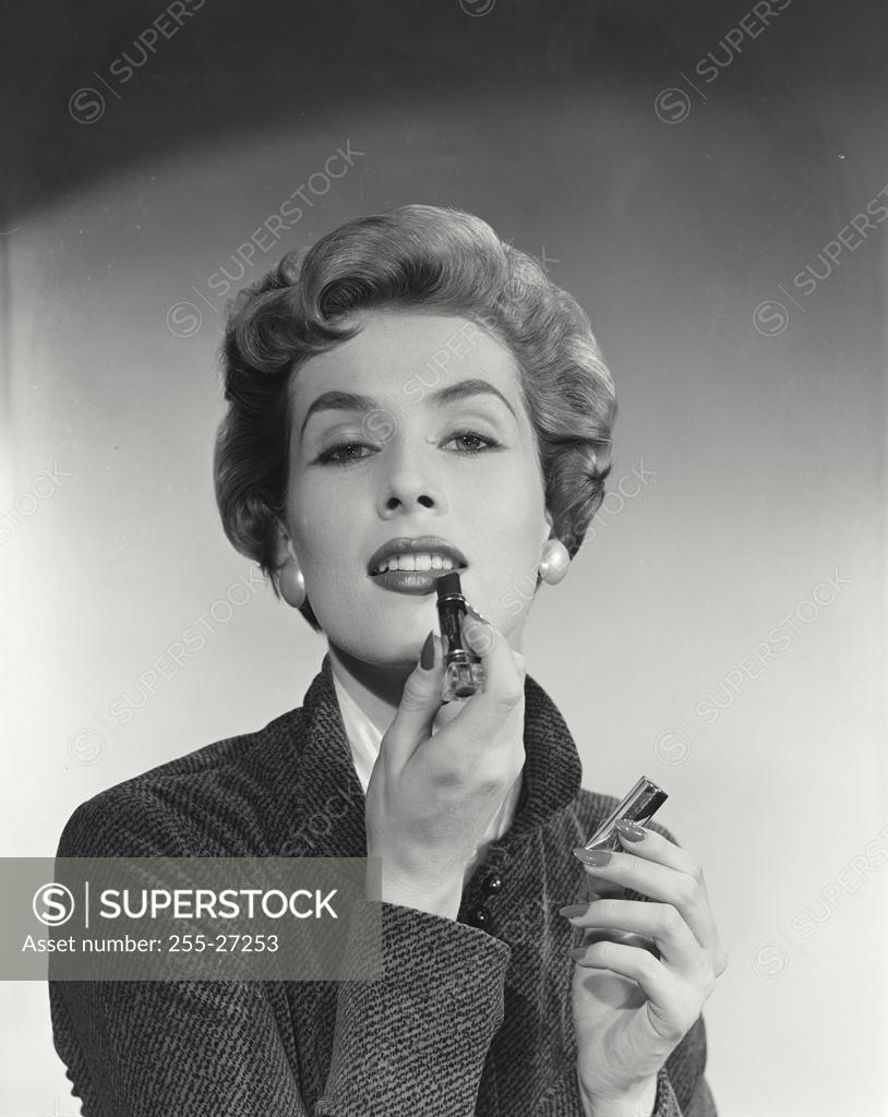 Stock Photo: 255-27253 Portrait of young woman applying lipstick