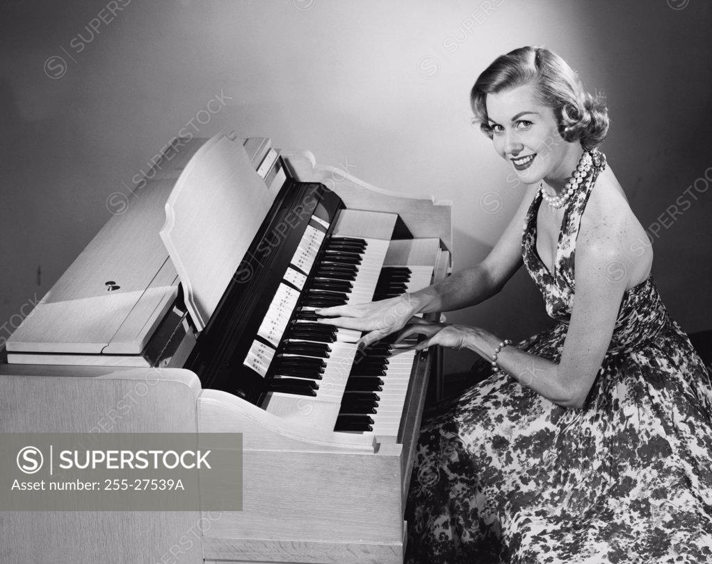 Stock Photo: 255-27539A Portrait of a young woman playing an organ