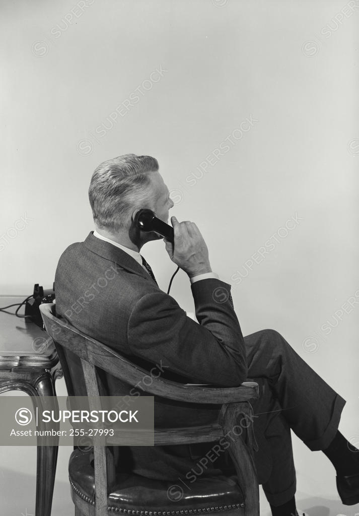 Stock Photo: 255-27993 Side Profile of a businessman using a telephone
