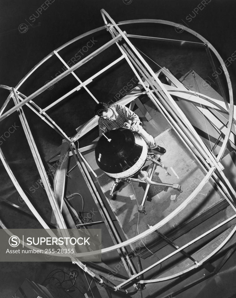 Stock Photo: 255-28355 High angle view of a scientist working on a space probe in a laboratory, Pioneer V, Cape Canaveral, Florida, USA