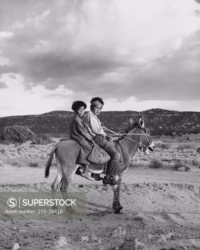 Stock Photo: 255-28418 Navajo boys riding a donkey, Monument Valley, Arizona, USA