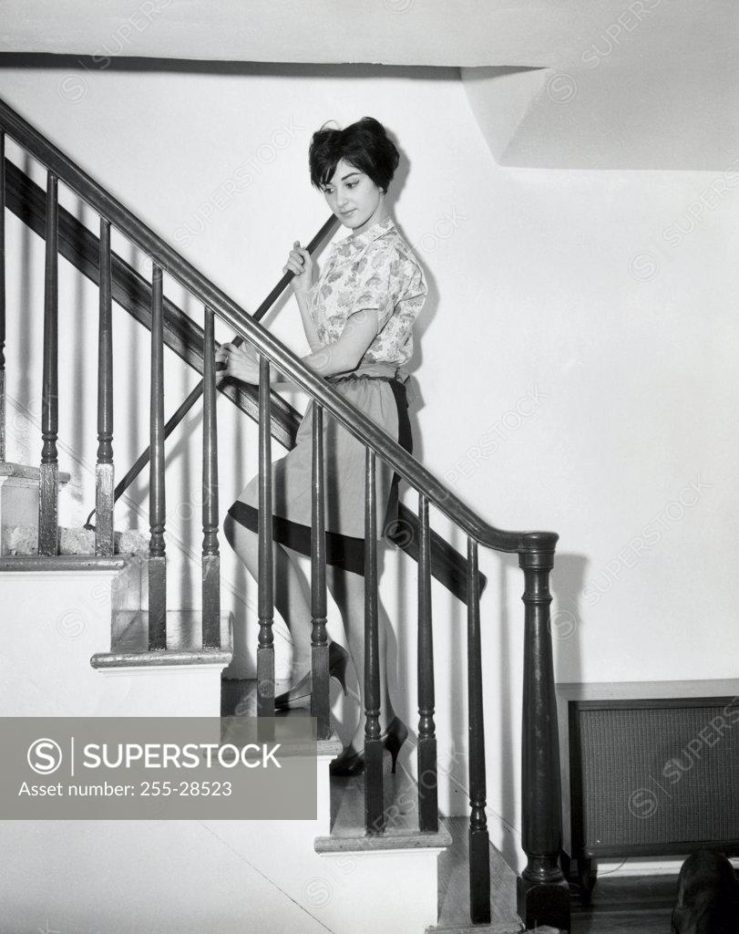 Stock Photo: 255-28523 Side profile of a young woman cleaning stairs with a mop