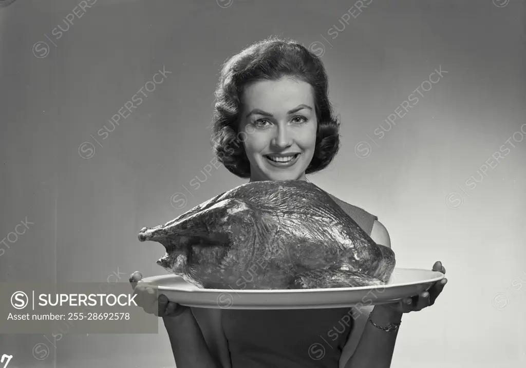 Vintage Photograph. Lucy Cort. Model Released. Portrait of woman in sleeveless blouse holding turkey.