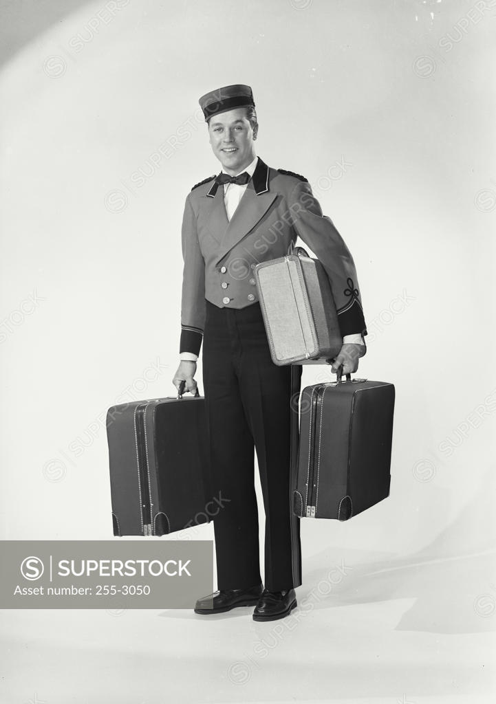 Stock Photo: 255-3050 Portrait of a bellhop carrying luggage
