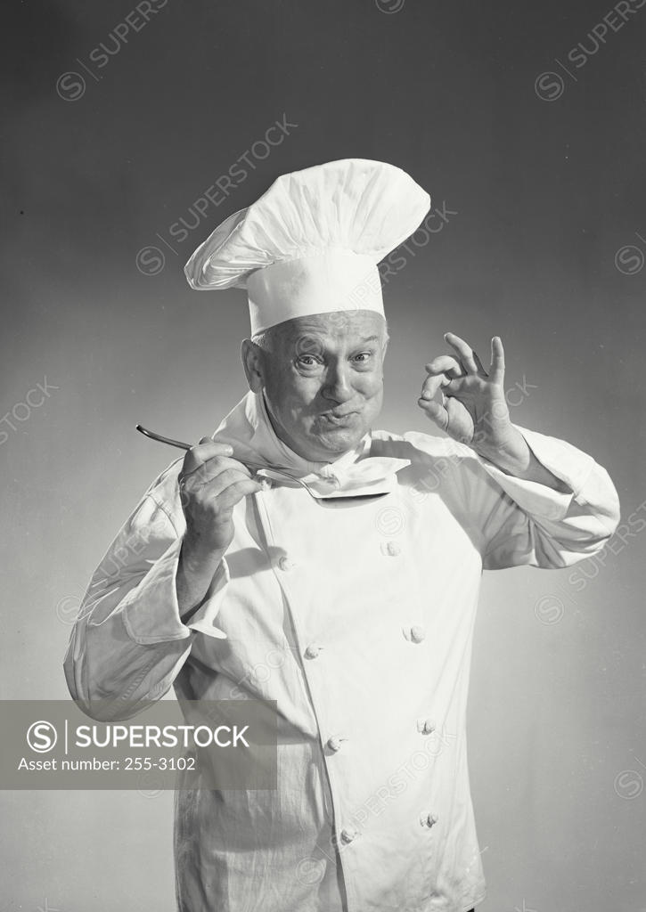 Stock Photo: 255-3102 Portrait of a chef tasting the food with a spoon