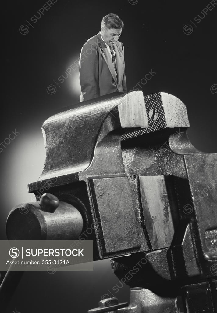 Stock Photo: 255-3131A Side profile of a businessman standing in a vise grip