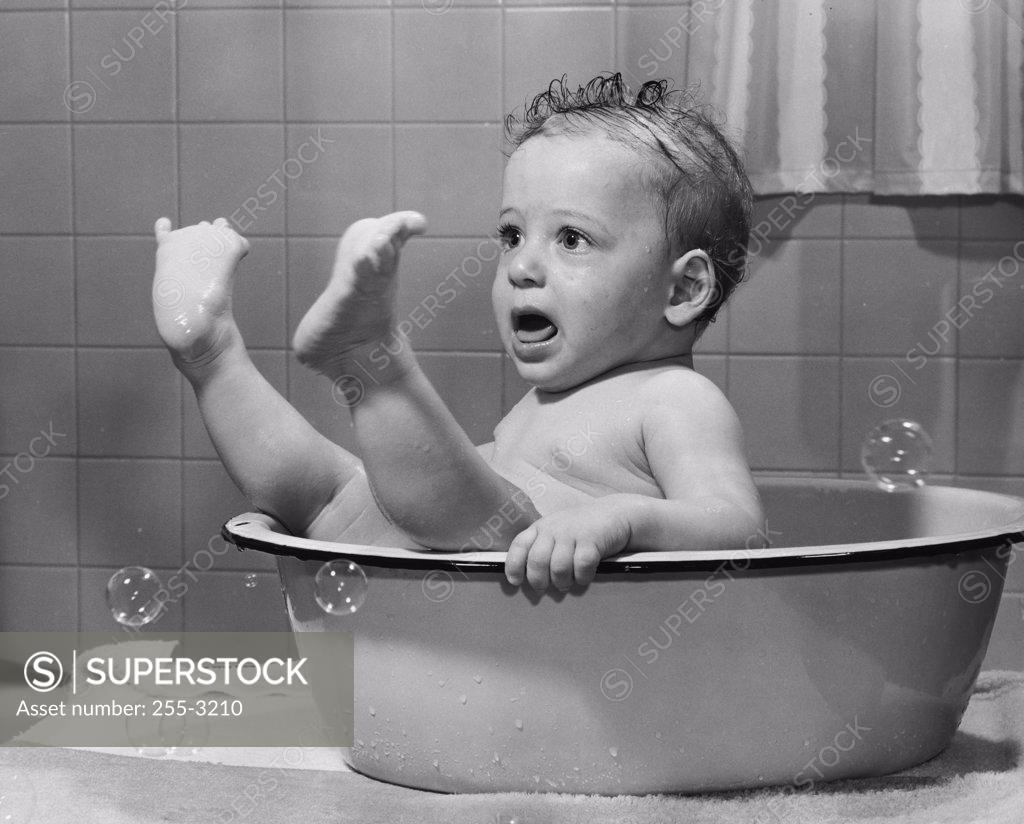 Stock Photo: 255-3210 Close-up of a baby boy in a bathtub with his feet up
