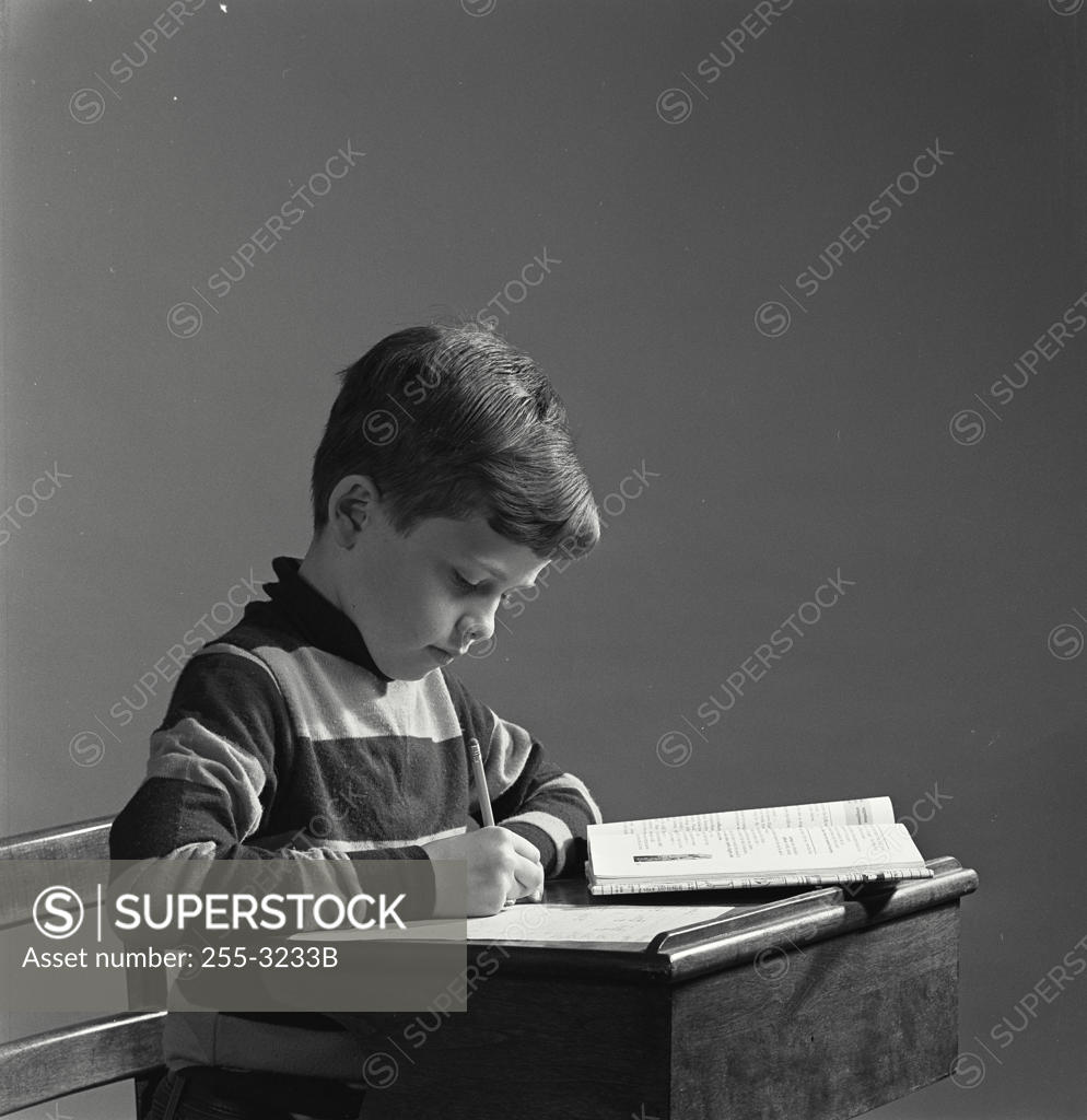 Stock Photo: 255-3233B Boy writing with a pencil on a notepad