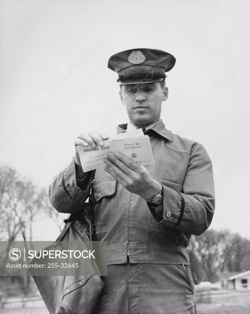 Stock Photo: 255-32645 Close-up of a postman holding mail