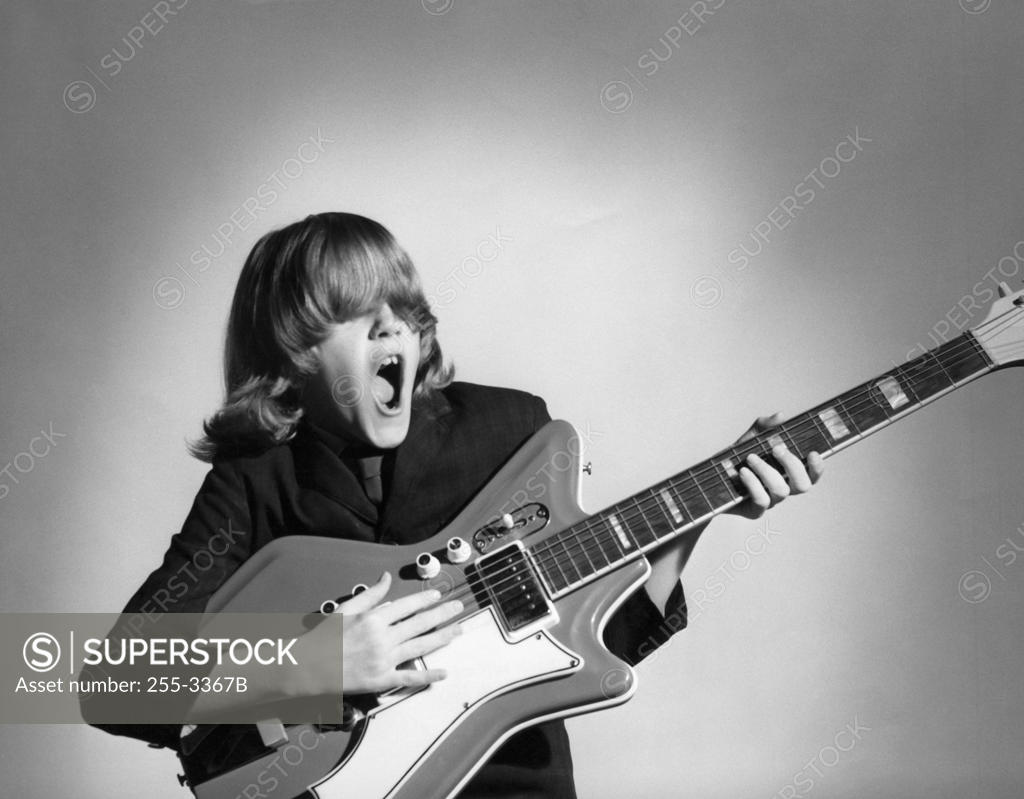 Stock Photo: 255-3367B Teenage boy playing a guitar and singing