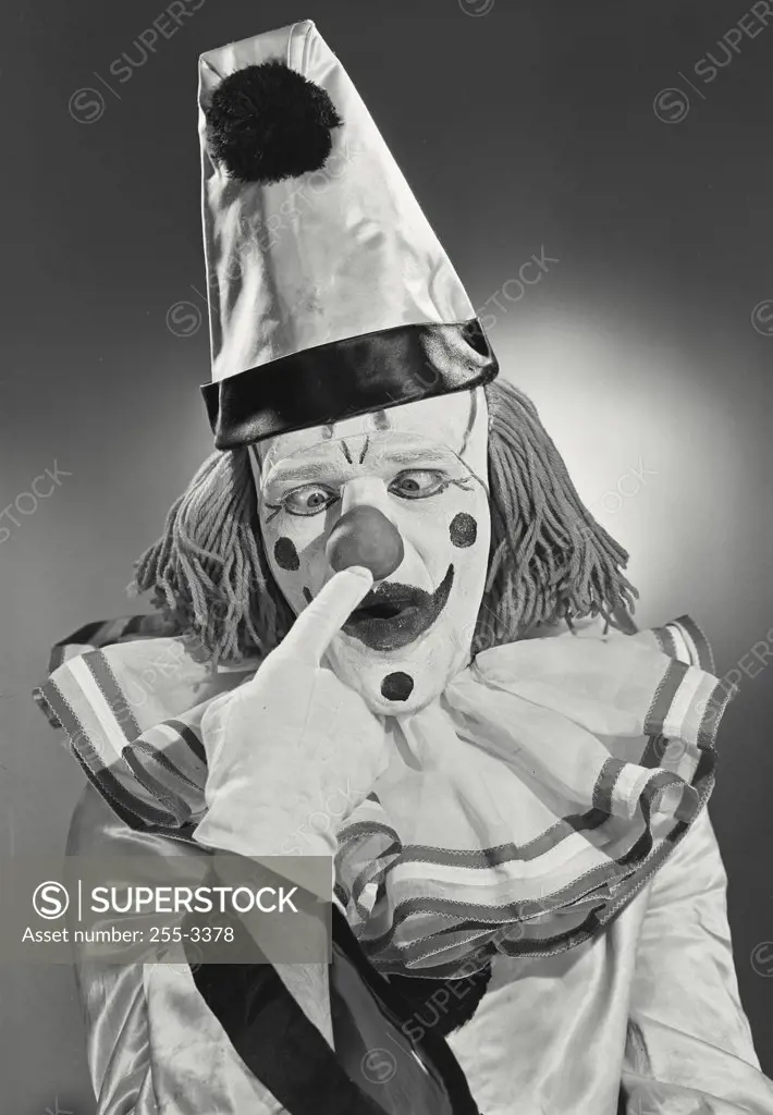 Vintage photograph. Portrait of clown wearing silly hat poking nose