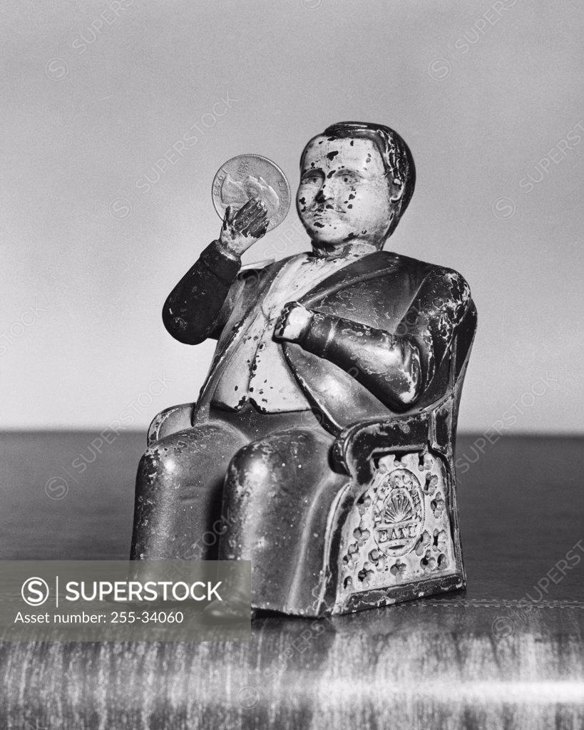 Stock Photo: 255-34060 Close-up of a figurine with a coin