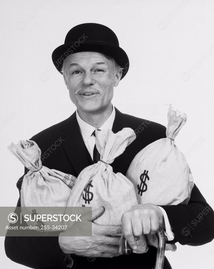 Stock Photo: 255-34207 Portrait of a businessman holding three bags of money