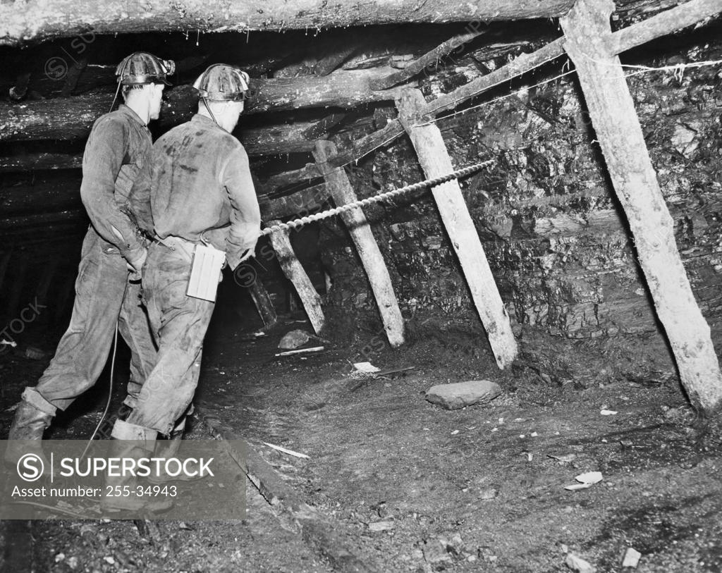 Stock Photo: 255-34943 Side profile of two coal miners drilling in the wall of a pit mine, Minersville, Pennsylvania, USA, Drilling