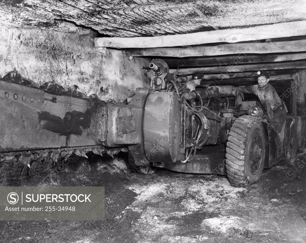 Stock Photo: 255-34948 Coal miner operating a cutting machine in a coal mine