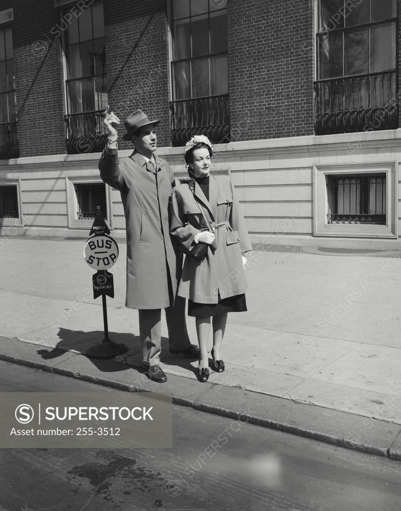 Stock Photo: 255-3512 Young man and a young woman waiting at a bus stop