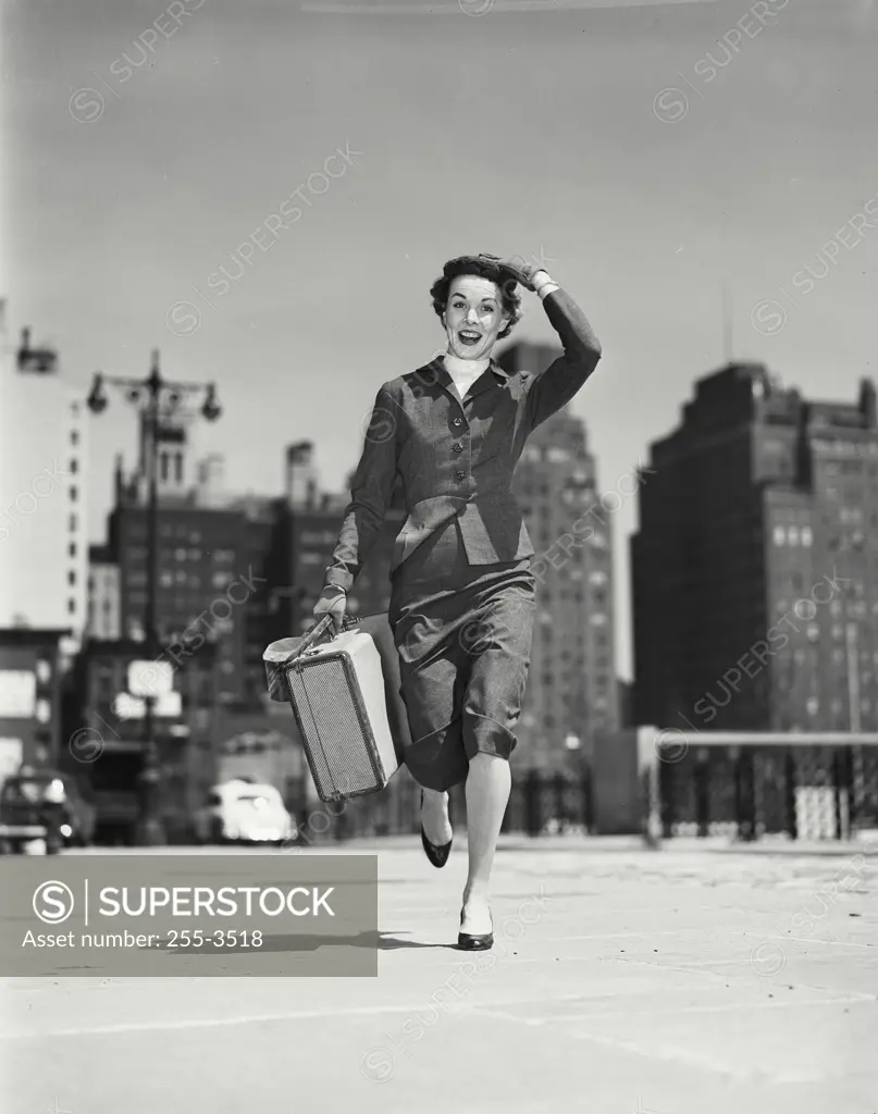 Portrait of young woman carrying suitcase