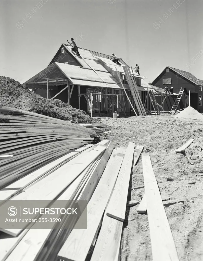 Scene in subdivision, houses under construction, roofing